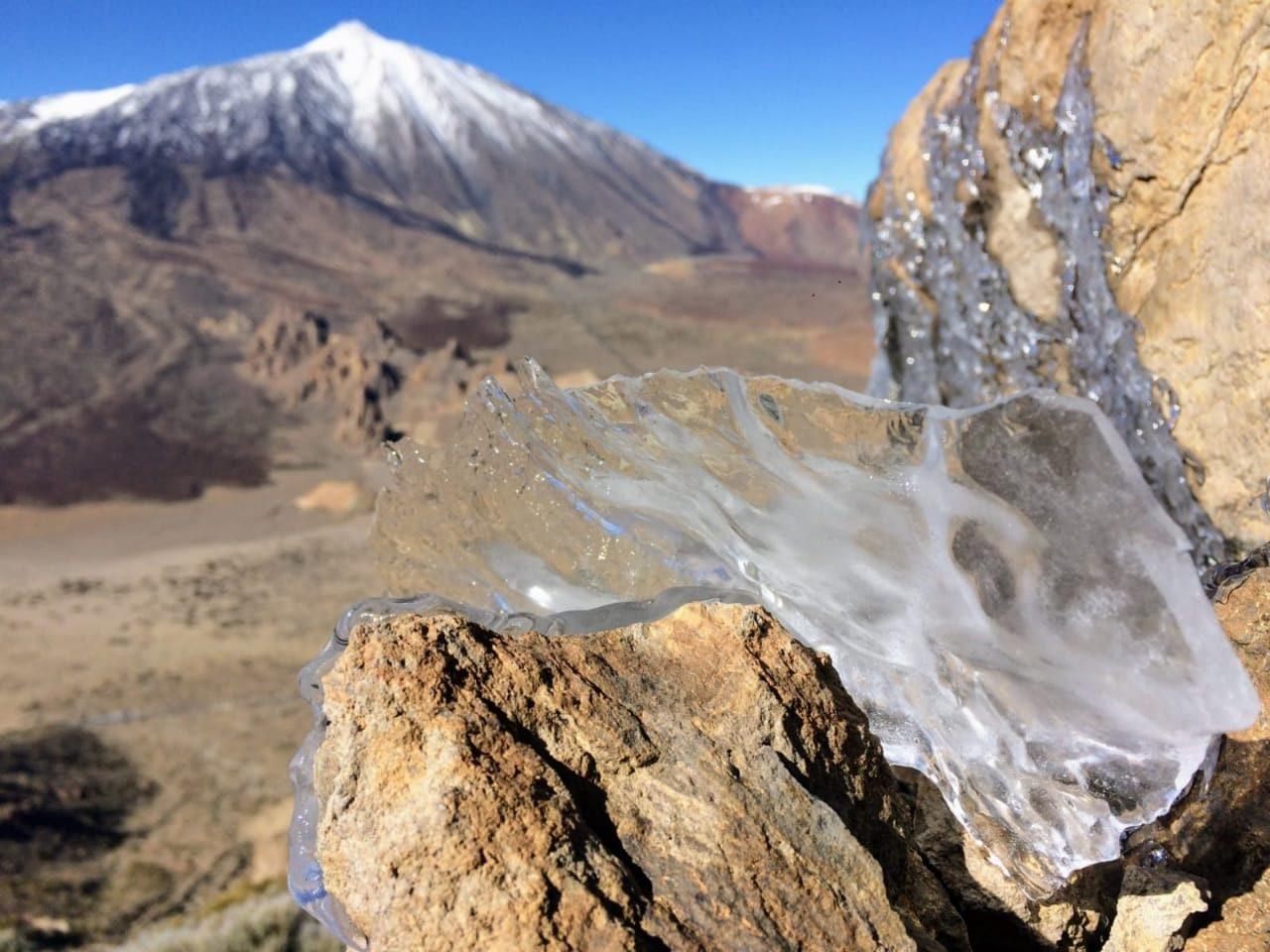 Ice on volcanic rock, mountain behind