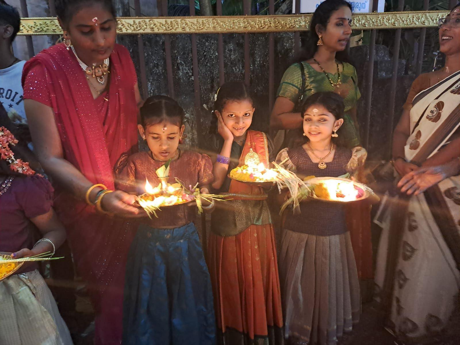 Girls carrying lamps at a temple ritual